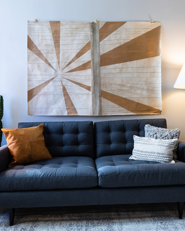 A calm therapy office seating area with a couch, warm lamp light, and artwork
